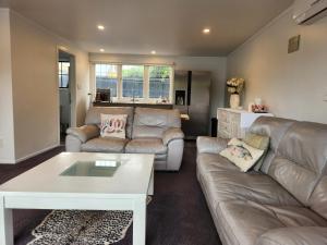 a living room with a couch and a table at Cedar House in Gisborne