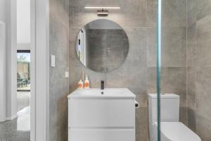 bagno con lavandino bianco e specchio di Barn 944 - Big Omaha Holiday Home a Matakana