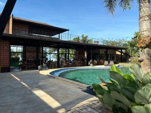 a house with a swimming pool in front of a building at GajaPuri Resort Koh Chang in Ko Chang