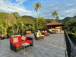 a patio with couches and a gazebo and palm trees at GajaPuri Resort Koh Chang in Ko Chang