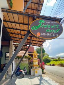 a sign for an airport hotel with motorcycles parked outside at Jingjit Hotel in Krabi town
