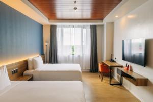 Urdaneta的住宿－Levo Hotel，酒店客房设有两张床和电视。