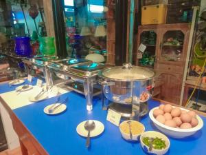 a counter with eggs and bowls of food on it at Jingjit Hotel in Krabi