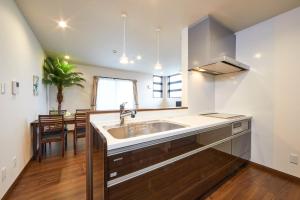 une cuisine avec un évier et un plan de travail dans l'établissement E-horizon Resort コンドミニアム名護E, à Nago