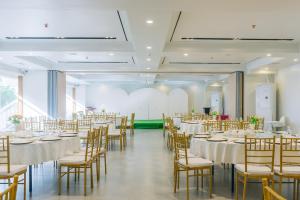 Urdaneta的住宿－Levo Hotel，宴会厅配有白色的桌椅