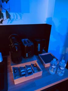 a desk with bottles of water on a blue background at Suite Dream by Need'Amour in Pontault-Combault