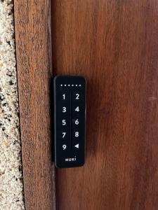 a black remote control on a wooden door at Suite Dream by Need'Amour in Pontault-Combault