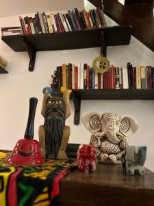 stół z posągami i książkami na półce w obiekcie Hostalito Las Mercedes w mieście Asunción