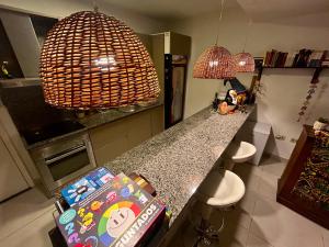 a kitchen with a counter with two stools and two lamps at Hostalito Las Mercedes in Asunción