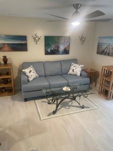 Sala de estar con sofá azul y mesa de centro en Stylish Coastal Townhome in Jupiter, en Jupiter