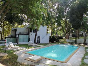 a swimming pool in the yard of a house at Vorona Resort in Sai Yok