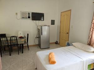 Zimmer mit einem Kühlschrank, einem Tisch und einem Esszimmer in der Unterkunft Jackys homestay in Bug-ong