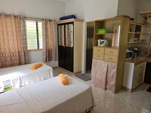 a room with two beds and a kitchen at Jackys homestay in Bug-ong