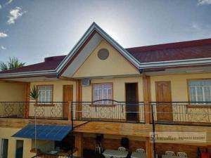 a house with a large deck with a balcony at Dantes place in Lumban