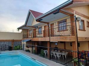 een huis met een balkon en een zwembad bij Dantes place in Lumban