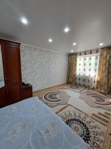 a bedroom with a large bed and a large rug at 408 квартал in Semey