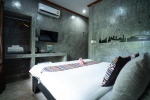a bedroom with a white bed and a tv at Siam Lanta Resort - SHA Extra Plus in Ko Lanta
