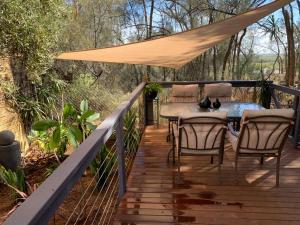 a wooden deck with a table and chairs on it at The Garden Cottage Pet Friendly in Renmark