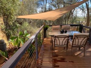 eine Holzterrasse mit einem Tisch und Stühlen darauf in der Unterkunft The Garden Cottage Pet Friendly in Renmark