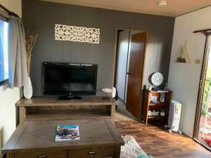 a living room with a flat screen tv and a coffee table at The Garden Cottage Pet Friendly in Renmark