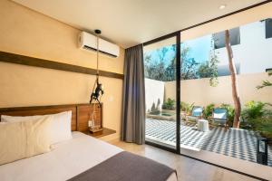 a bedroom with a bed and a view of a patio at Faisano Nomadas in Tulum