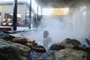 Eine Frau steht in einem Whirlpool, in einem sprudelnden, kalysikalischen Zustand in der Unterkunft THE FARM Resort Japan in Katori