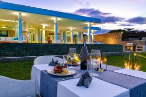 a table with a plate of food and a bottle of wine at Deep Blue Vila Managed by LBV in Singaraja