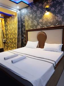 ein Bett mit zwei weißen Handtüchern darüber in der Unterkunft Rudraksha Inn in Varanasi