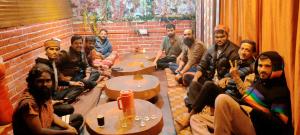 a group of men sitting in a room at Highland Gojh Kasol in Kasol