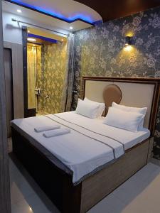 ein Schlafzimmer mit einem großen Bett mit weißer Bettwäsche in der Unterkunft Rudraksha Inn in Varanasi