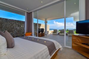 a bedroom with a large bed and a television at Deep Blue Vila Managed by LBV in Singaraja