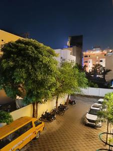 ein gelber Van auf einem Parkplatz mit Bäumen geparkt in der Unterkunft Rudraksha Inn in Varanasi