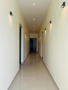 an empty hallway with white walls and lights at Cloud Beach Residency in Alleppey