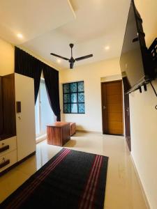 a living room with a couch and a ceiling fan at Cloud Beach Residency in Alleppey