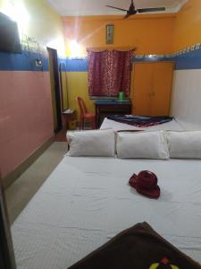 um quarto com duas camas e um chapéu vermelho na cama em PAYEL LODGE em Digha