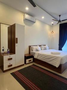 um quarto com uma cama grande e uma cómoda e uma cama sidx sidx em Cloud Beach Residency em Alappuzha