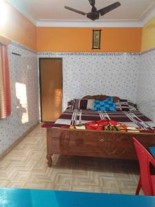 Schlafzimmer mit einem Bett und einem Deckenventilator in der Unterkunft PAYEL LODGE in Digha