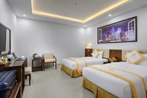 Habitación de hotel con 2 camas y TV de pantalla plana. en Merry Hotel en Da Nang