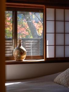 um vaso sentado num parapeito de janela num quarto em 京都 三日月 Mikazuki em Quioto