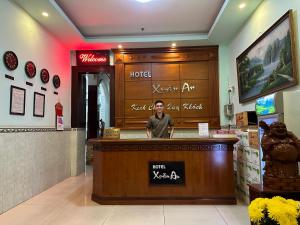 a man standing behind a counter in a restaurant at Xuân An Hotel - 53 Nguyễn Thái Bình, Q. Tân Bình - by Bay Luxury in Ho Chi Minh City
