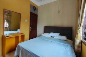1 dormitorio con 1 cama con espejo y 1 cama sidx sidx sidx sidx en OYO 93390 Griya Pius Syariah Malioboro, en Yogyakarta