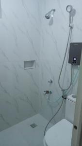 y baño con ducha, aseo y lavamanos. en Cozy 2 Bedroom (Entire House) Pearson Residences en Hulugan