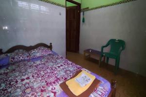 1 dormitorio con 1 cama y 1 silla verde en OYO 93394 Pondok Wisata Kurniawan 2, en Yogyakarta