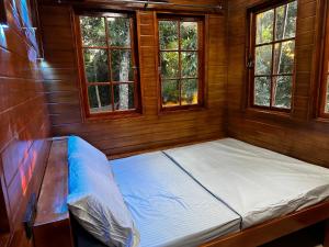 an empty bed in a room with windows at Tabique by the Sea in Asturias