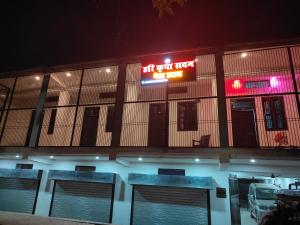 a building with a sign on the side of it at night at Hari Kripa Sadan in Ayodhya
