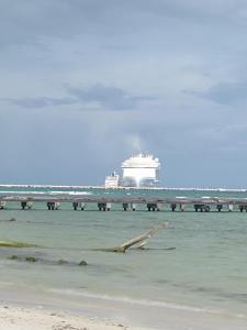 a cruise ship in the ocean with a pier at Maha cabin beach access in Mahahual