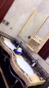 bagno con 2 lavandini e specchio di شاليه الراحة a Al Majmaah