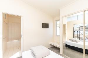 1 dormitorio con espejo, 1 cama y ducha en NRMA Eastern Beach Holiday Park, en Lakes Entrance 31 fotos más