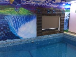 una piscina con un dipinto di una cascata di شاليه الراحة a Al Majmaah