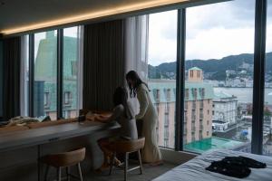 two women standing at a desk in a hotel room at FAV LUX Nagasaki in Nagasaki